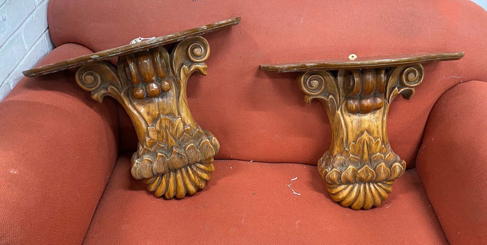 A pair of Victorian style carved walnut wall brackets, width 53cm, height 48cm